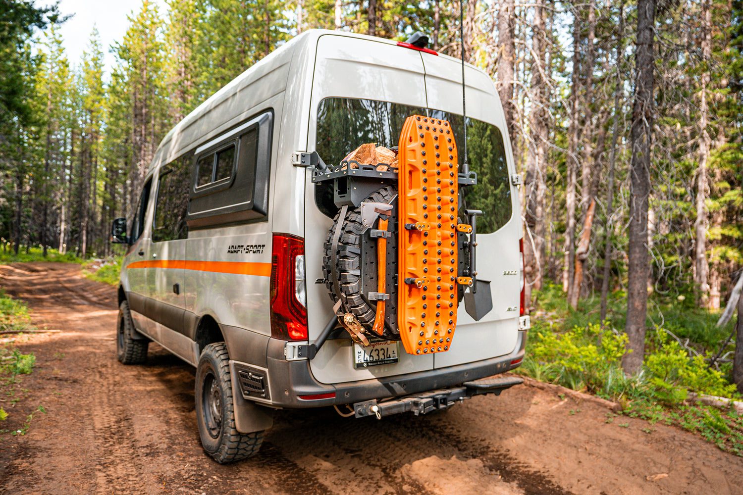 Otzi van on a forest trail with recovery boards mounted on the rear